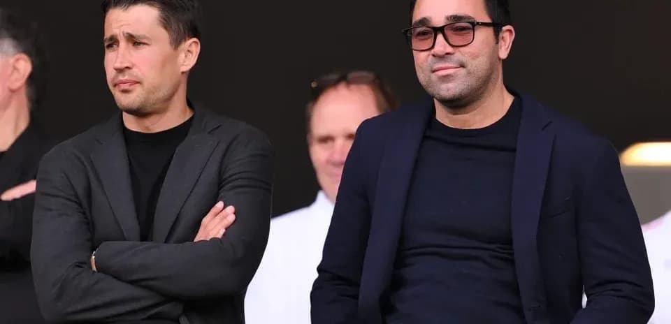 Deux hommes en costume dans les tribunes du stade