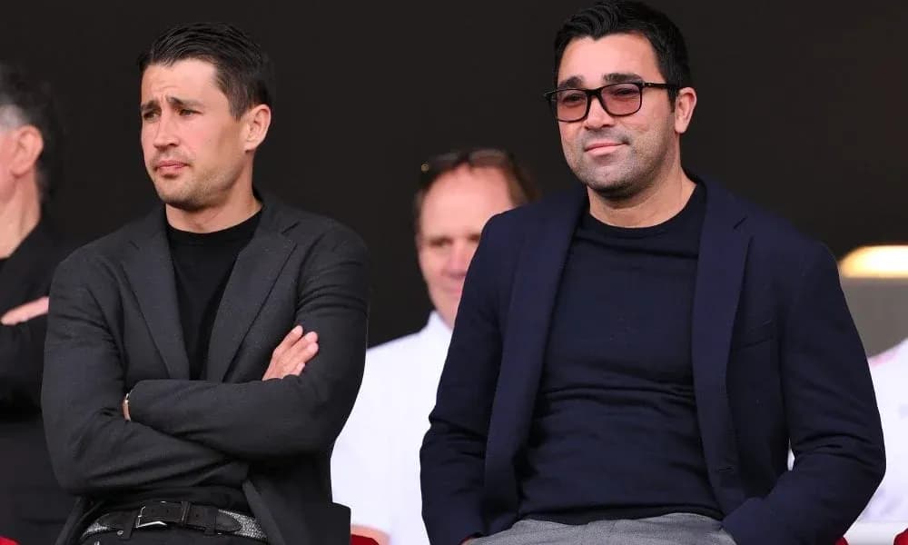 Deux hommes en costume dans les tribunes du stade