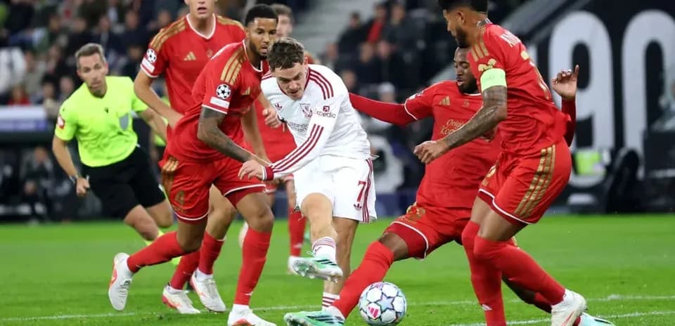 Joueur dribblant entre plusieurs défenseurs lors du match