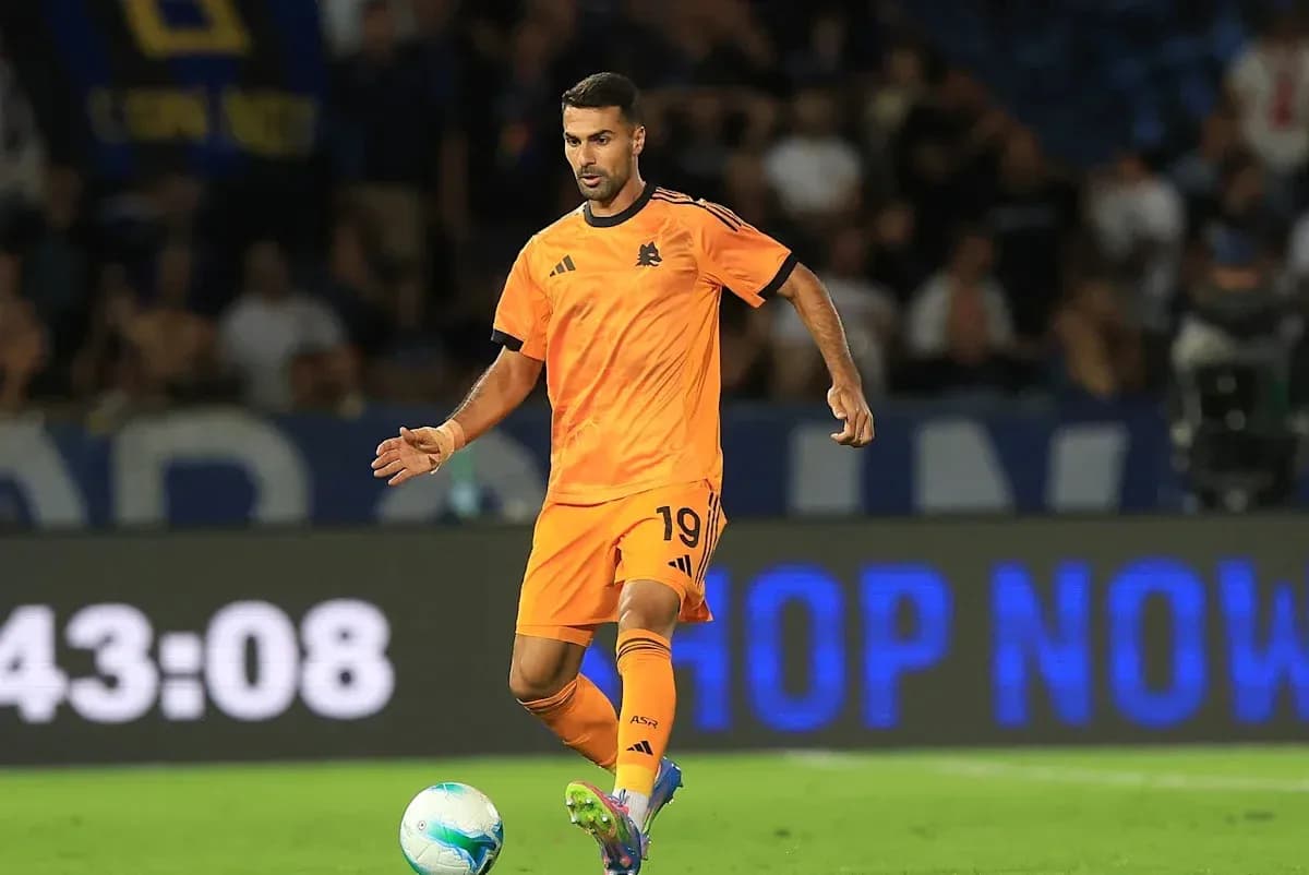 Joueur en maillot orange dribblant le ballon sur le terrain