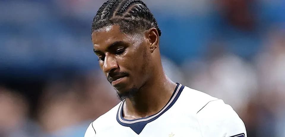 Joueur de football portant un maillot blanc, regard baissé