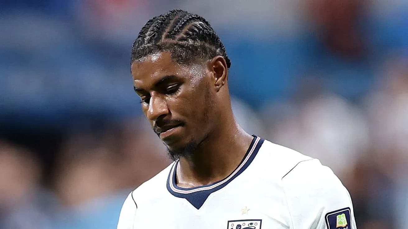 Joueur de football portant un maillot blanc, regard baissé
