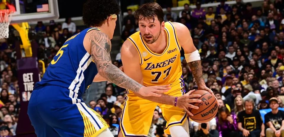 Joueur des Lakers dribblant face à un adversaire