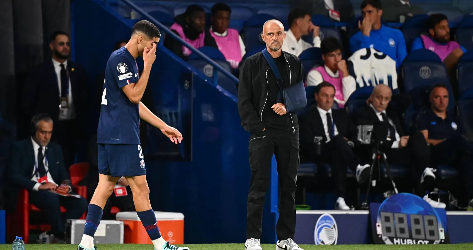 Joueur quittant le terrain avec entraîneur observant