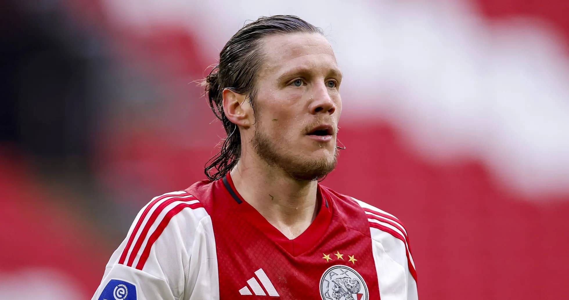 Joueur d'Ajax en tenue rouge et blanche sur le terrain