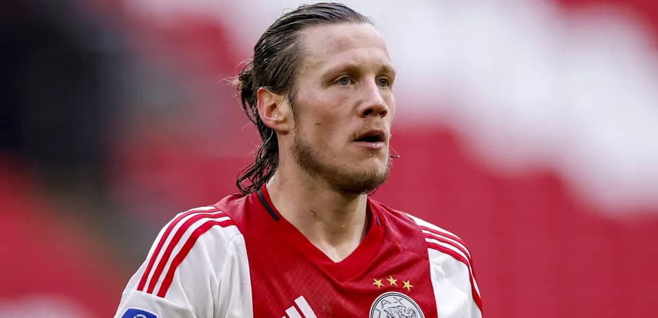 Joueur d'Ajax en tenue rouge et blanche sur le terrain