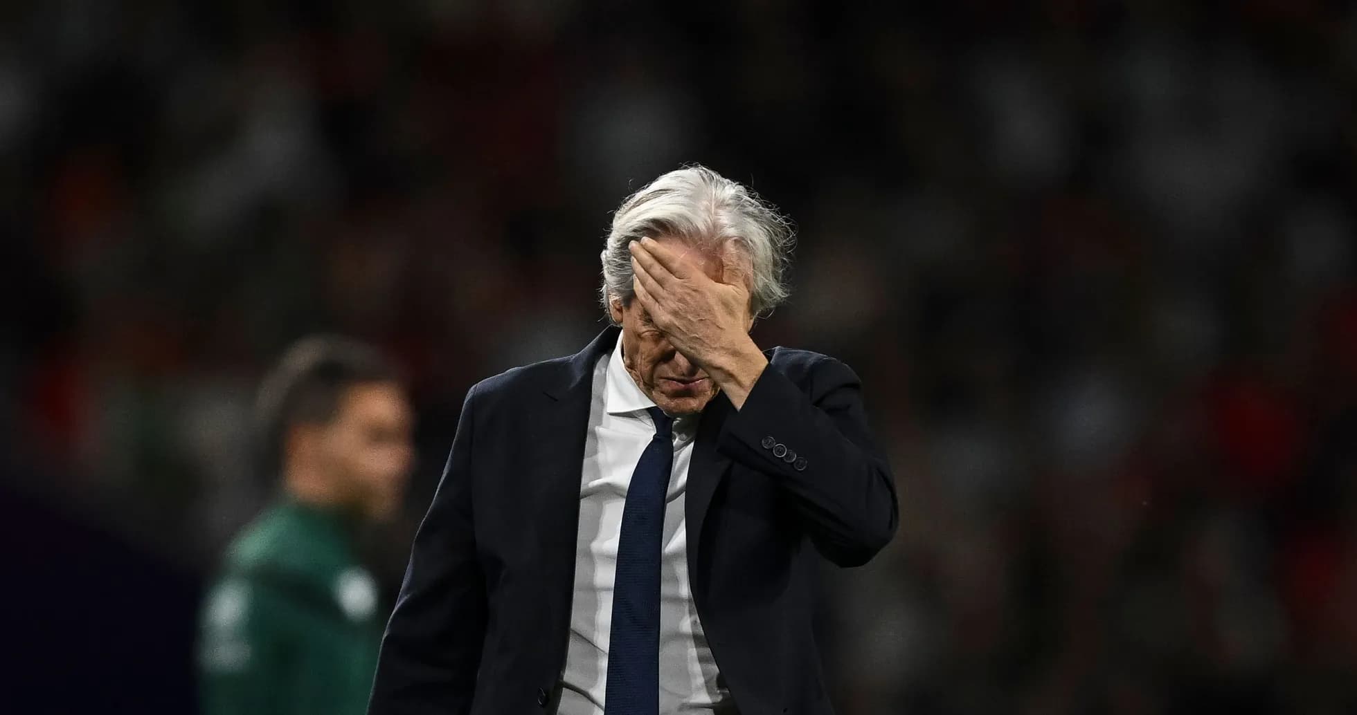 Entraîneur se tenant le visage après le match