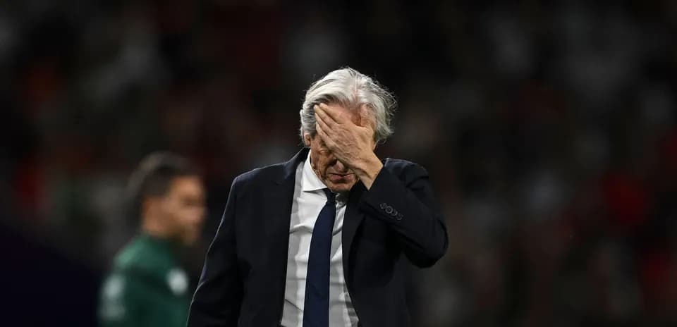 Entraîneur se tenant le visage après le match