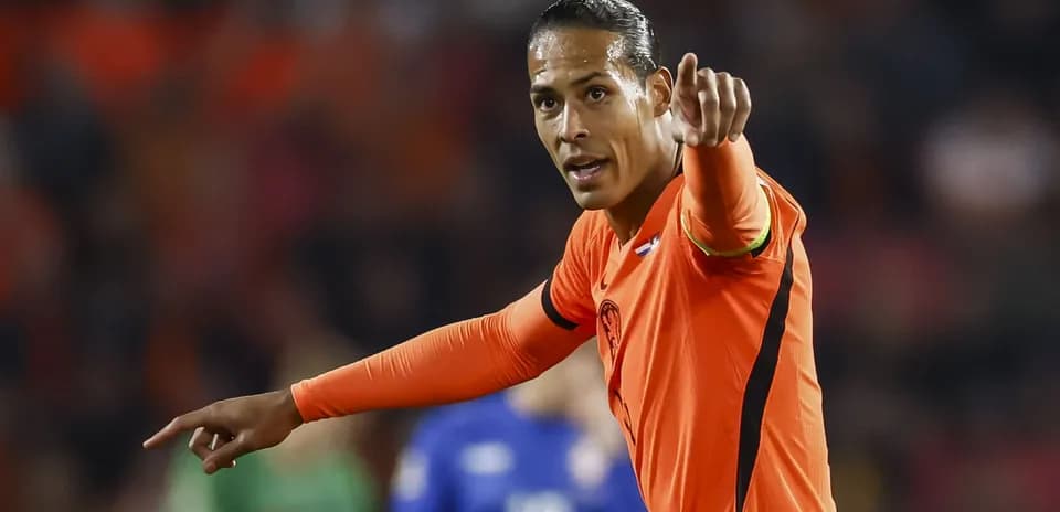 Joueur en maillot orange donnant des instructions sur le terrain