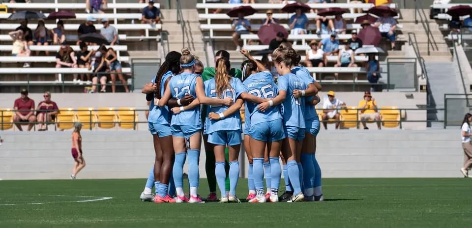Équipe de football féminin en cercle avant le match