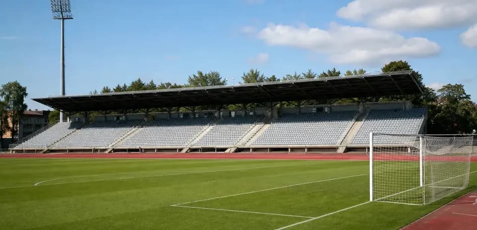 Stade de football avec tribunes vides et pelouse