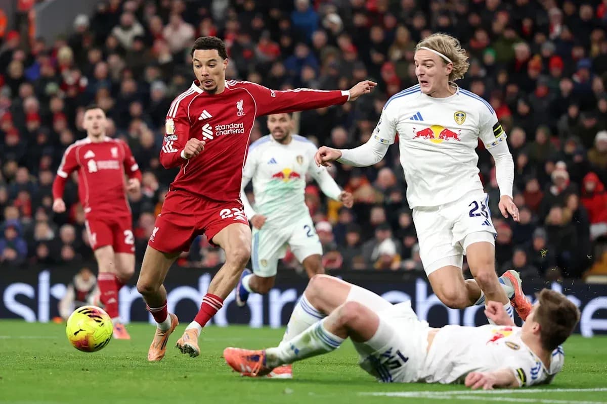 Joueur de Liverpool dribblant entre deux joueurs de Leeds