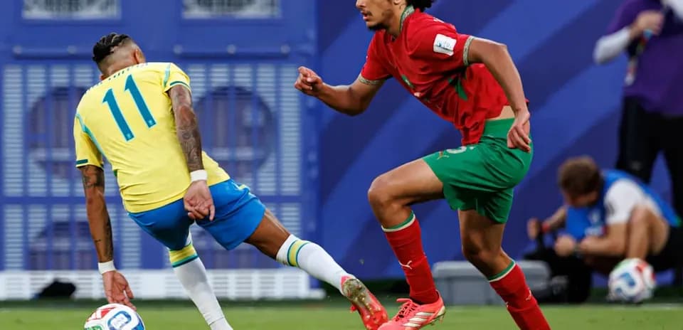 Joueur brésilien dribblant un défenseur marocain