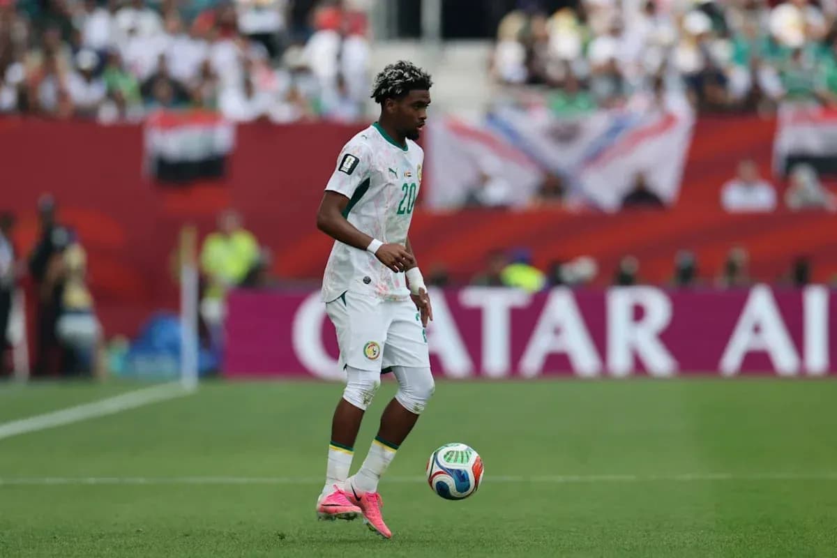 Joueur sénégalais dribblant le ballon sur le terrain