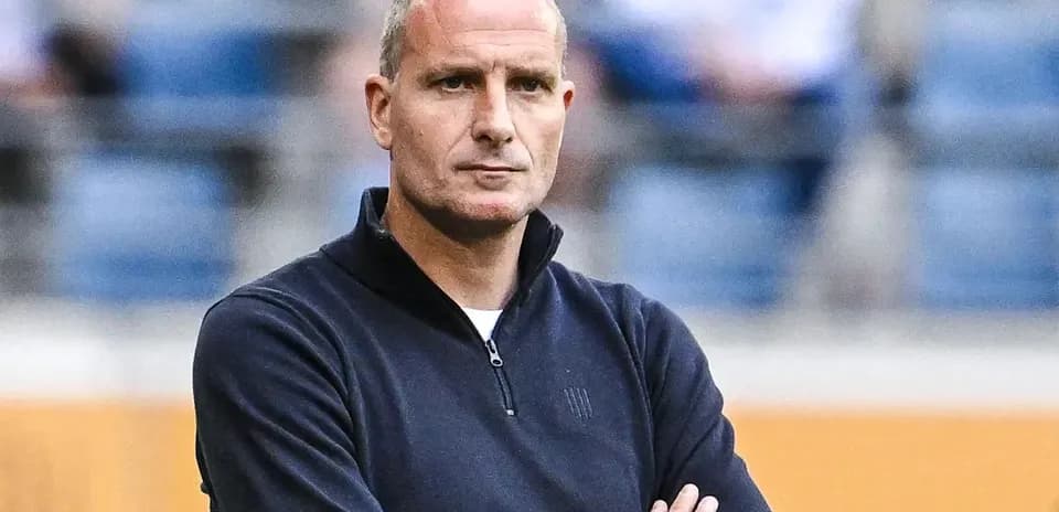 Entraîneur observant le match avec les bras croisés