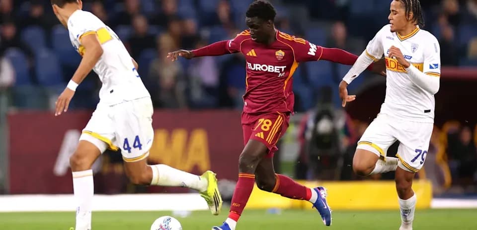 Joueur de l'AS Roma dribblant deux adversaires