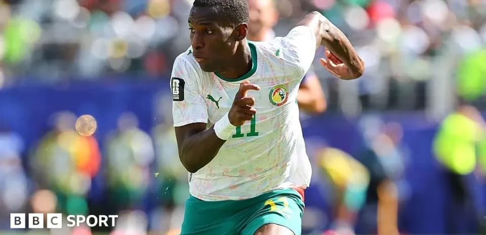 Joueur sénégalais courant sur le terrain de football