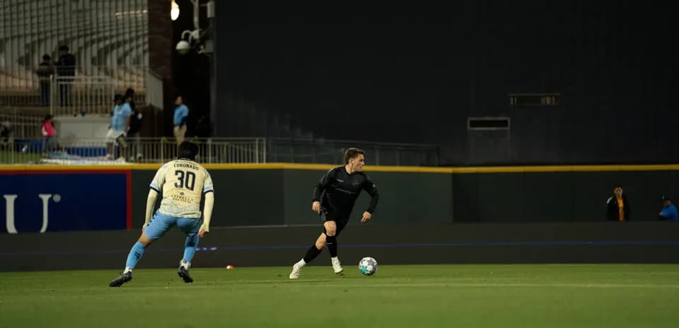 Un joueur dribble le ballon sur le terrain