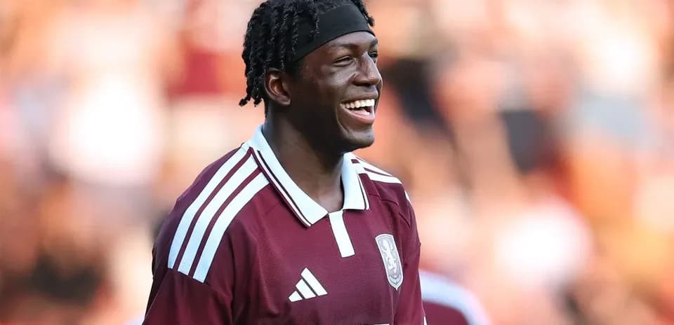 Joueur souriant en maillot maroon sur le terrain