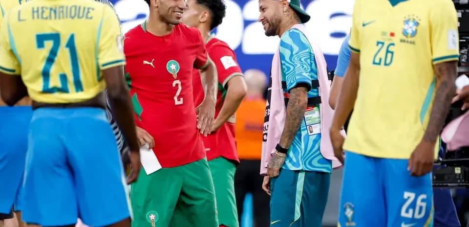 Joueurs marocains et brésiliens discutant sur le terrain