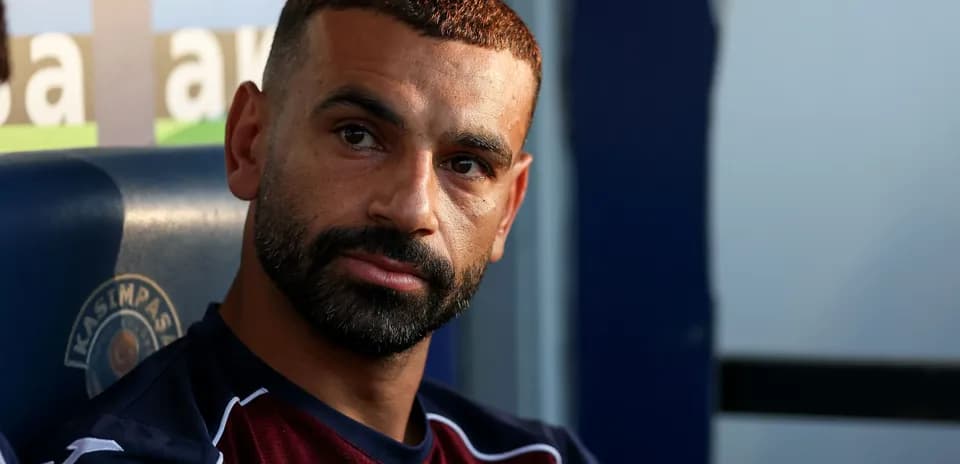 Joueur assis sur le banc de touche, regard pensif