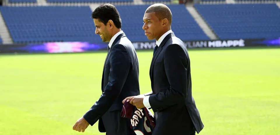 Kylian Mbappé et un dirigeant marchant sur le terrain