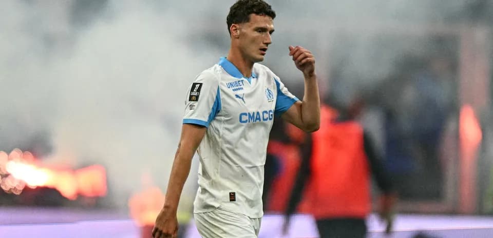 Joueur de l'OM marchant sur le terrain en fumée