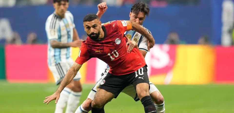 Joueur égyptien dribblant contre un joueur argentin