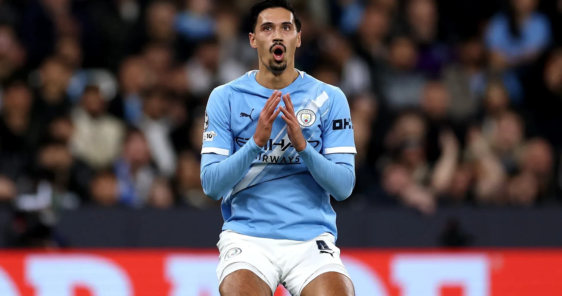 Joueur de Manchester City priant sur le terrain