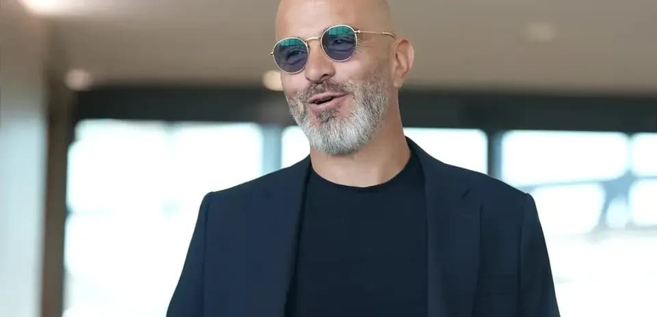 Homme avec lunettes de soleil souriant dans un hall