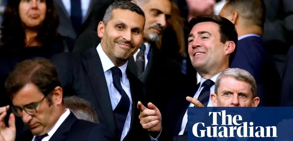 Deux hommes souriant dans les tribunes d'un stade