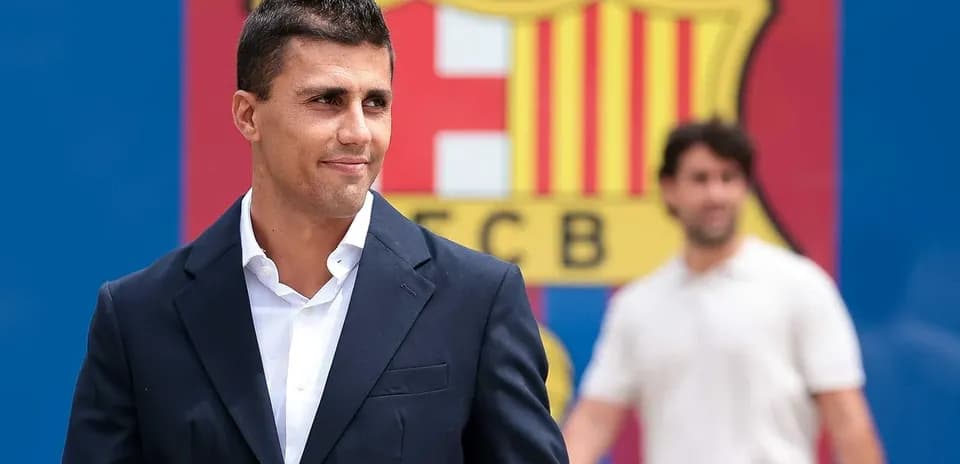Homme en costume devant logo du FC Barcelone