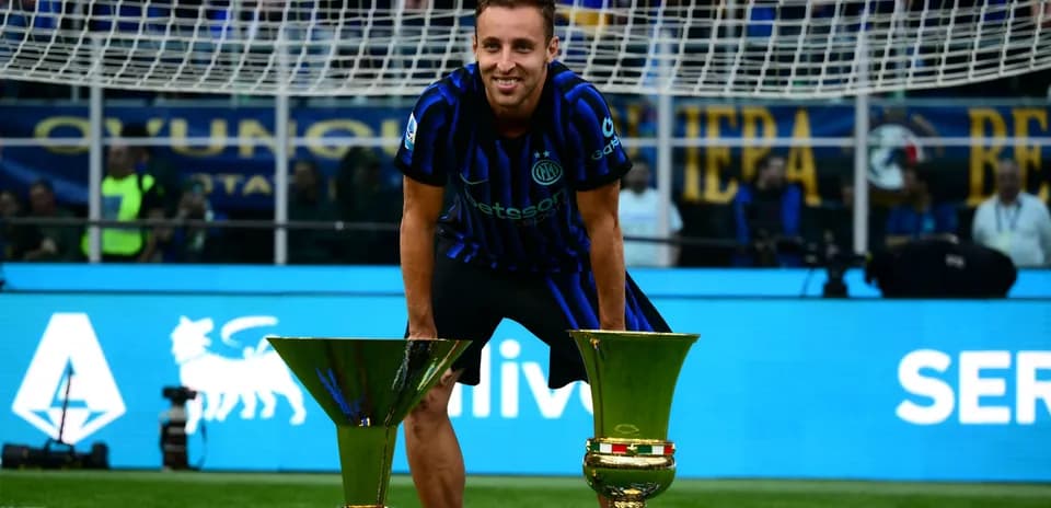 Joueur posant avec deux trophées sur le terrain