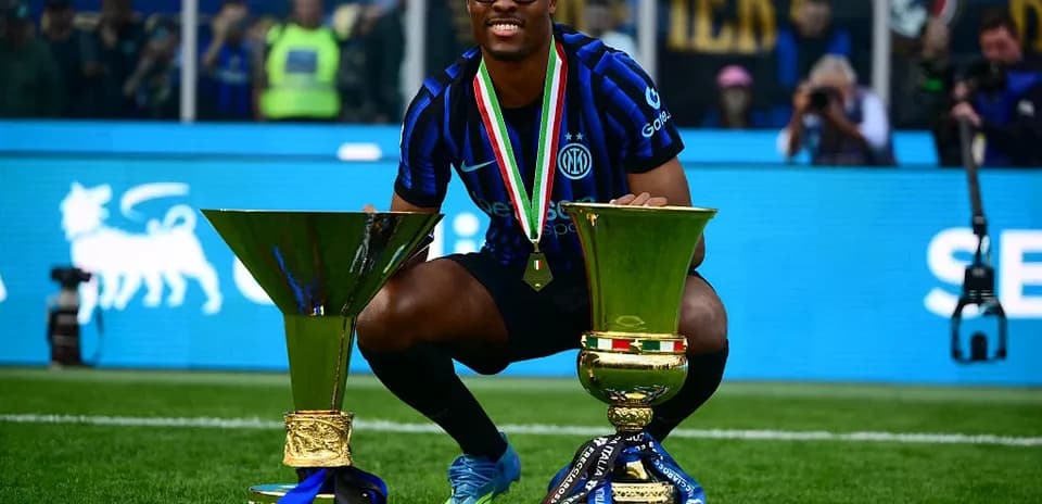 Joueur célébrant avec deux trophées de football