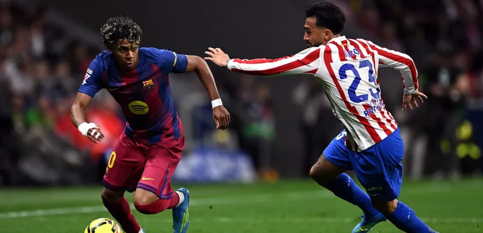 Joueur de Barcelone dribblant un adversaire d'Atletico