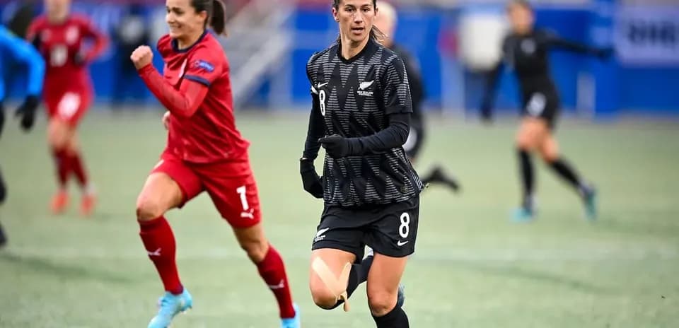 Joueuse en noir courant sur le terrain de football
