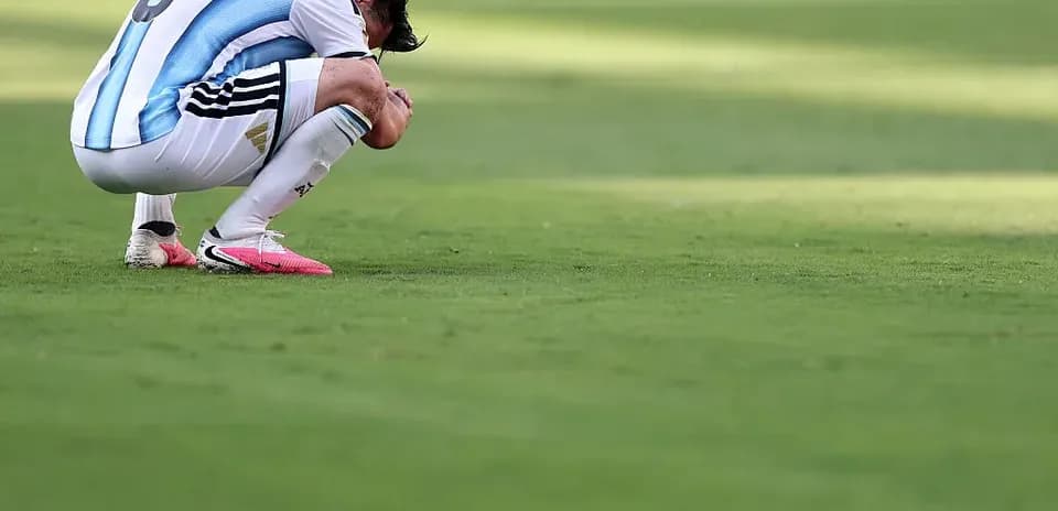 Joueur argentin accroupi sur le terrain après un match
