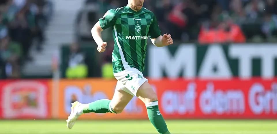 Joueur de football courant avec le ballon sur le terrain