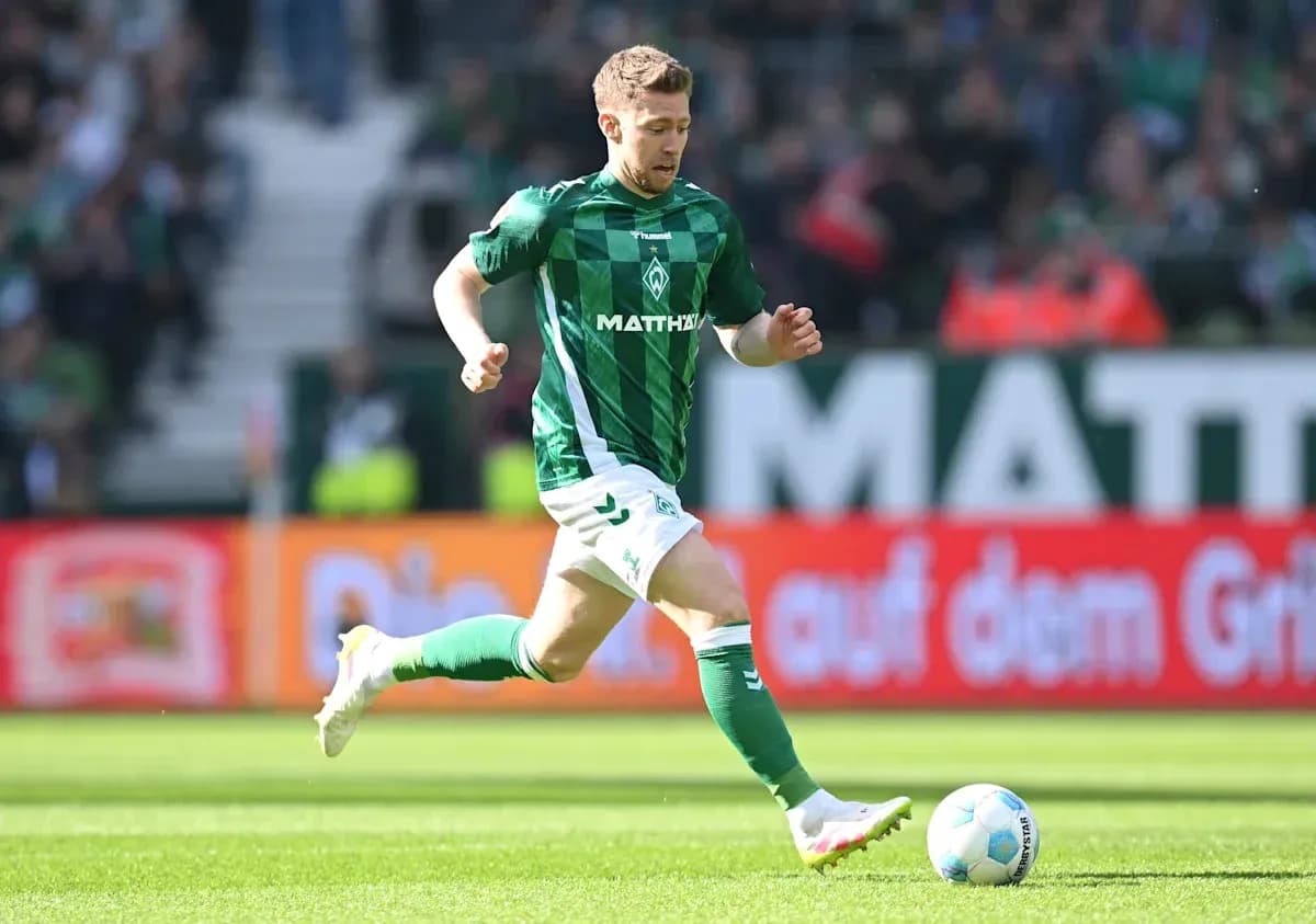 Joueur de football courant avec le ballon sur le terrain
