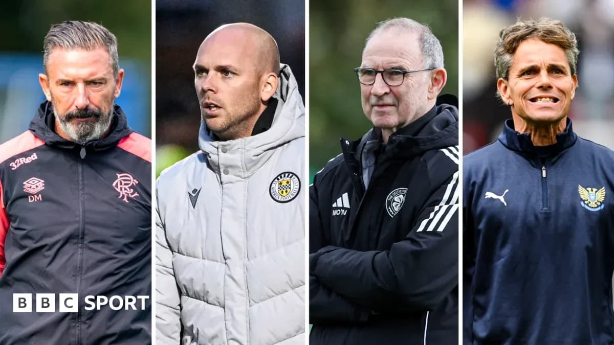 Quatre entraîneurs de football en discussion sur le terrain