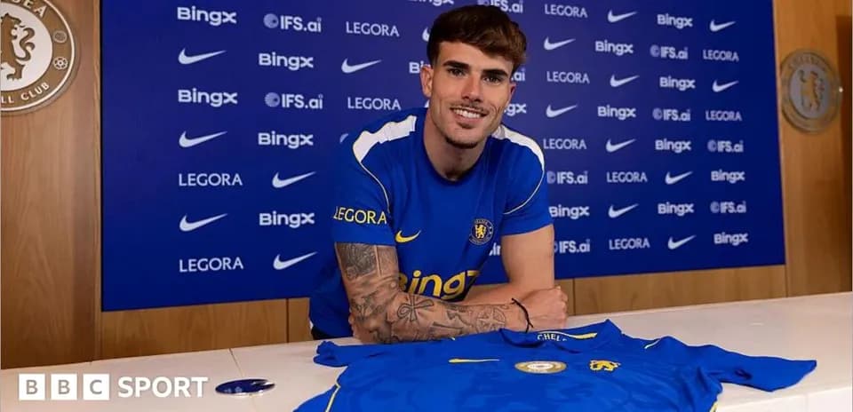 Joueur posant avec maillot de Chelsea à la conférence