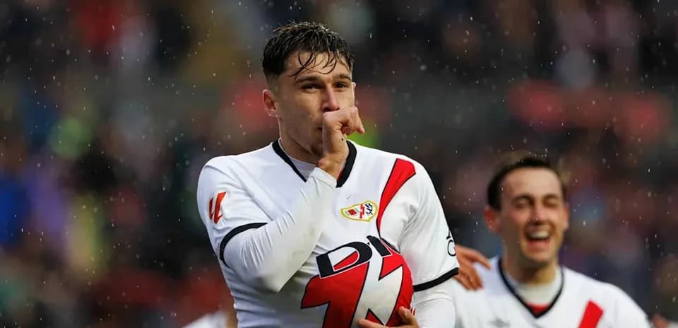 Joueur célébrant avec le ballon sous la pluie
