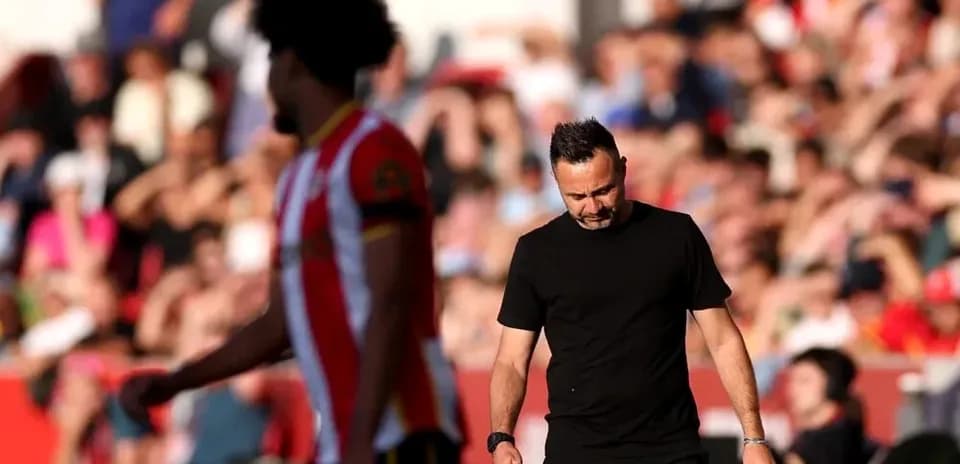 Entraîneur marchant sur le terrain, joueur en arrière-plan