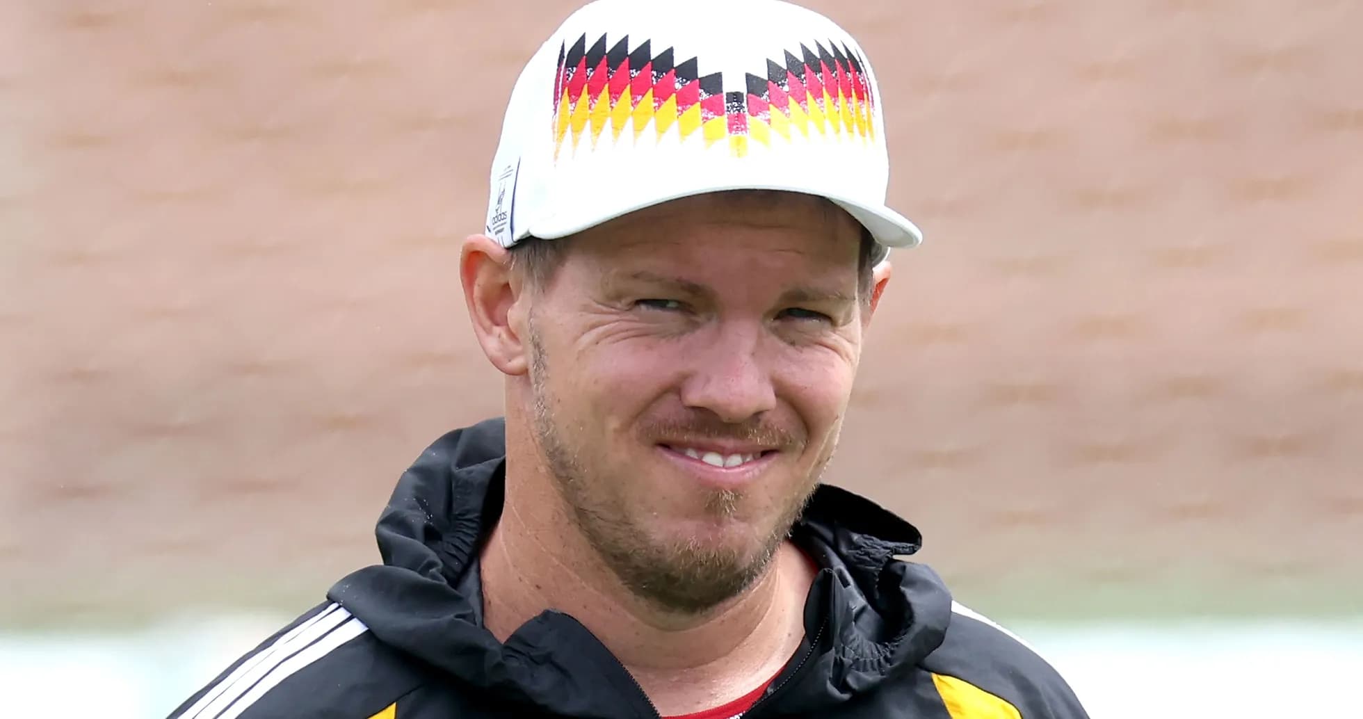 Entraîneur souriant portant une casquette lors d'un entraînement