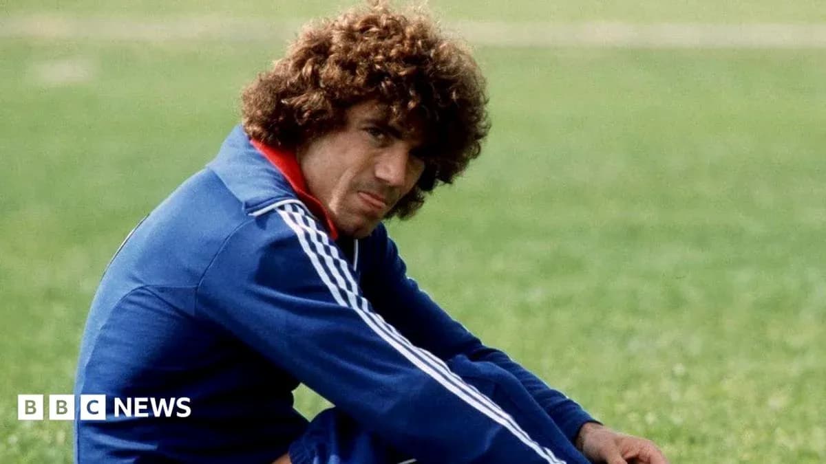 Joueur assis sur le terrain, portant un survêtement