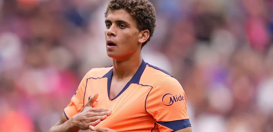 Joueur en tenue orange sur le terrain de football