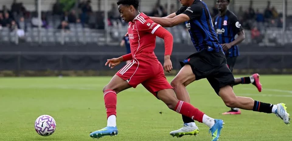 Joueur dribblant avec adversaire en poursuite sur le terrain