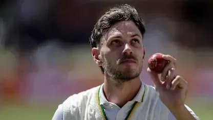 Joueur de cricket tenant une balle sur le terrain