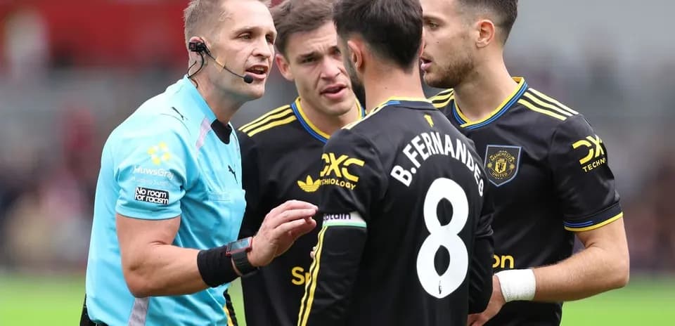 L'arbitre discute avec des joueurs de Manchester United