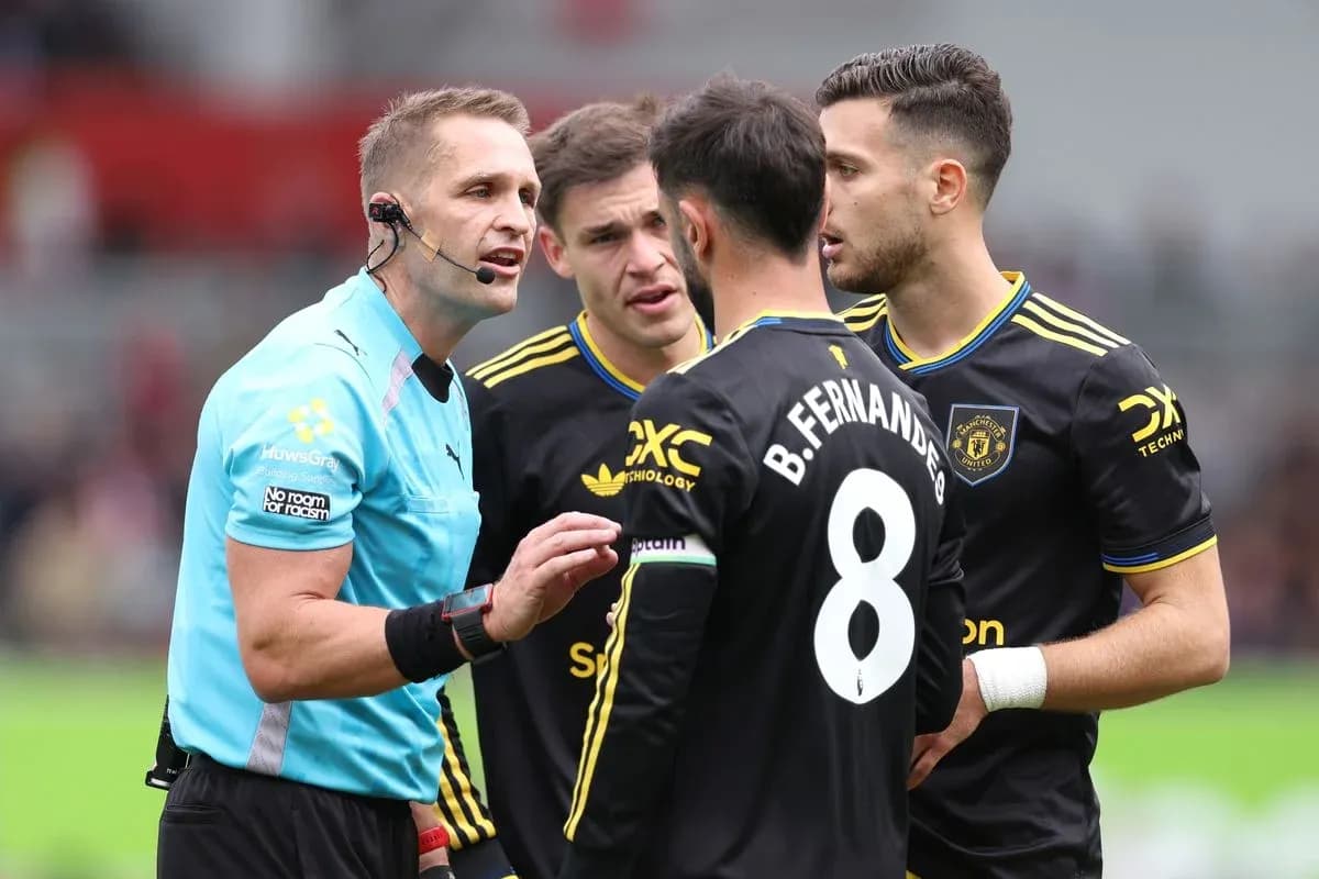 L'arbitre discute avec des joueurs de Manchester United